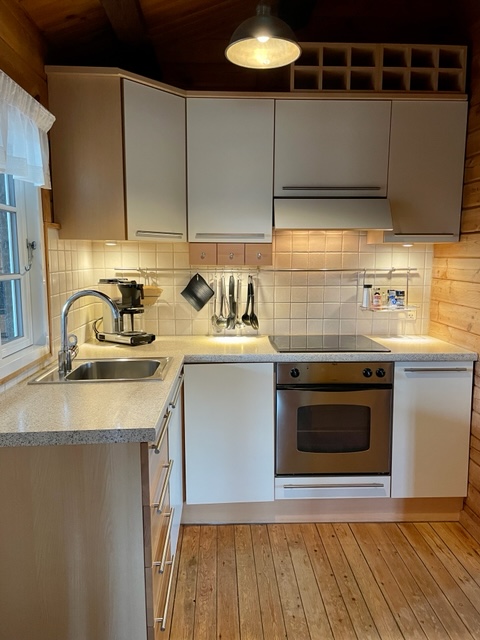 L�kkert lyst k�kken med alt i k�kkenudstyr. Ovn, keramisk kogeplader, k�leskab og fryser med tre mindre skuffer. 