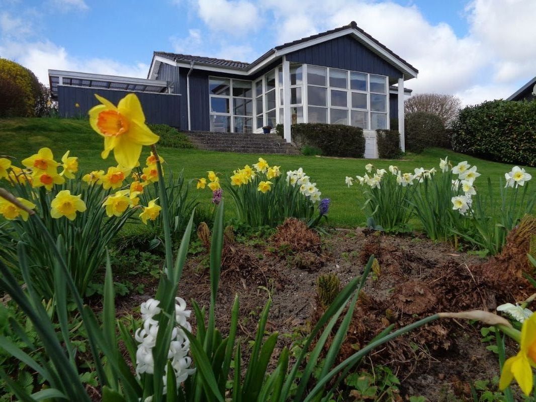 Sommerhuset set fra haven, ligger p en skrnende grund