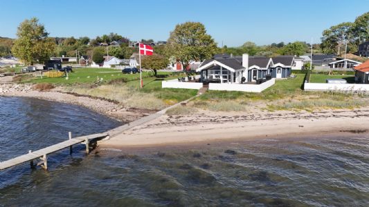 Hyggeligt familieejet sommerhus beliggende p� stranden, i roligt sommerhusomr�de, med panoramaudsigt over Genner Bugt.
